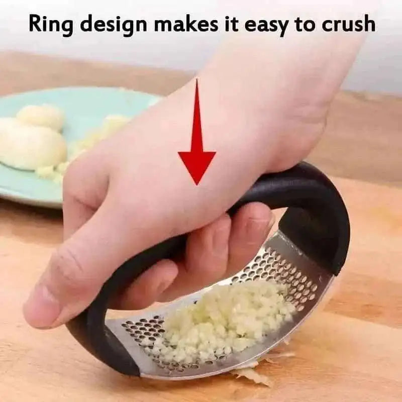 Garlic rocker press with black handle, minced garlic on stainless perforated grating