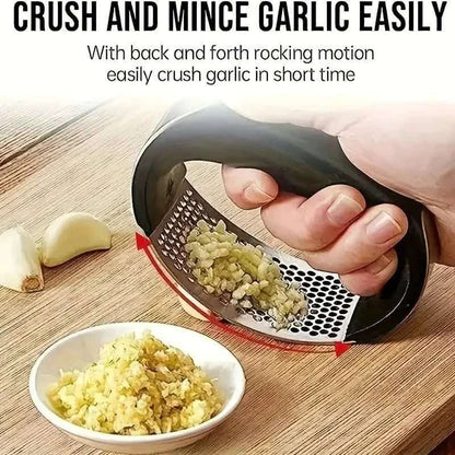 Black-handled garlic rocker press crushing garlic with minced garlic in a bowl