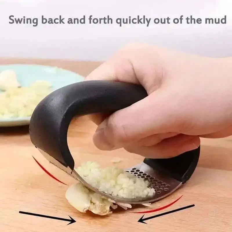 Garlic rocker press tilted in a rocking motion, minced garlic on perforated steel surface