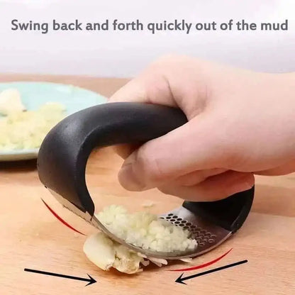 Garlic rocker press tilted in a rocking motion, minced garlic on perforated steel surface