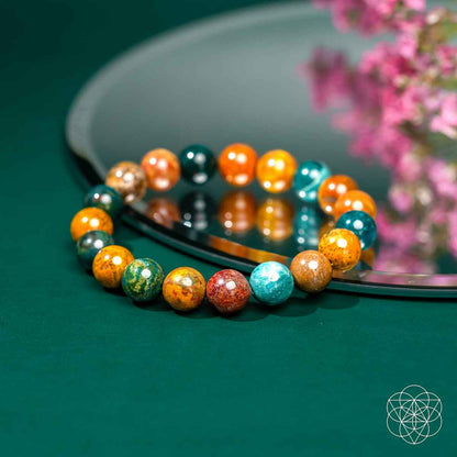 Beaded bracelet with teal, orange, and dark green round gemstone beads