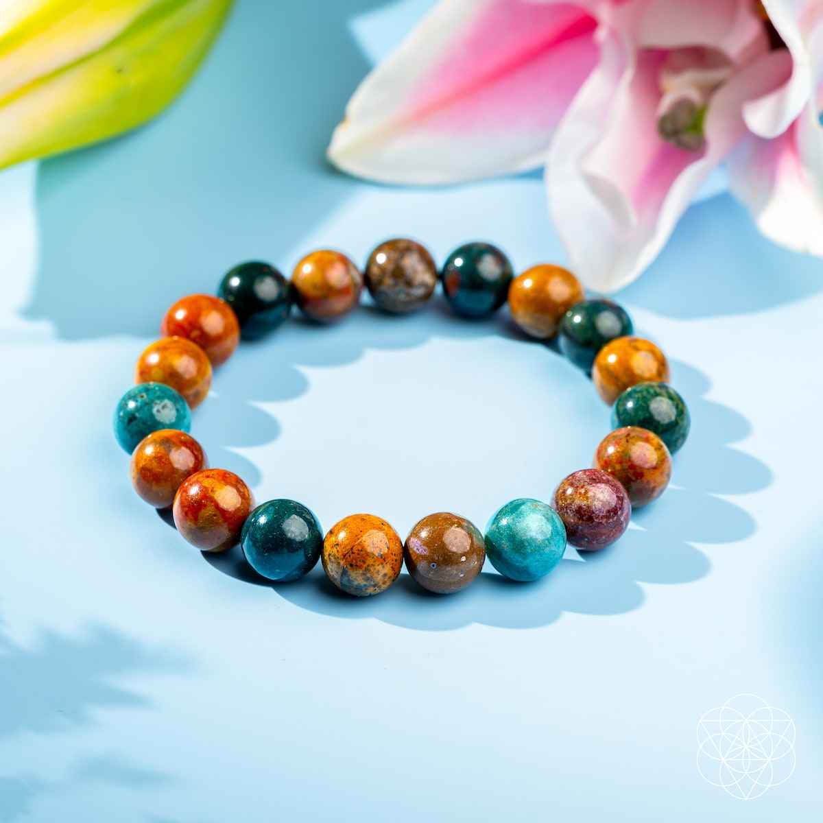 Beaded bracelet with teal, orange, and dark green round stones, speckled accents
