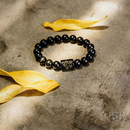 Obsidian bead protection bracelet with dark round beads and gold-tone center charm