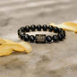 Obsidian bead protection bracelet with dark round beads and a square gold-tone charm
