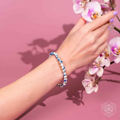 Blue and white beaded bracelet on wrist with round gemstone beads