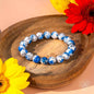 Beaded blue and white stone bracelet on wooden tray