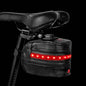 Rear bike saddle bag under black saddle; red LED strip lit along front