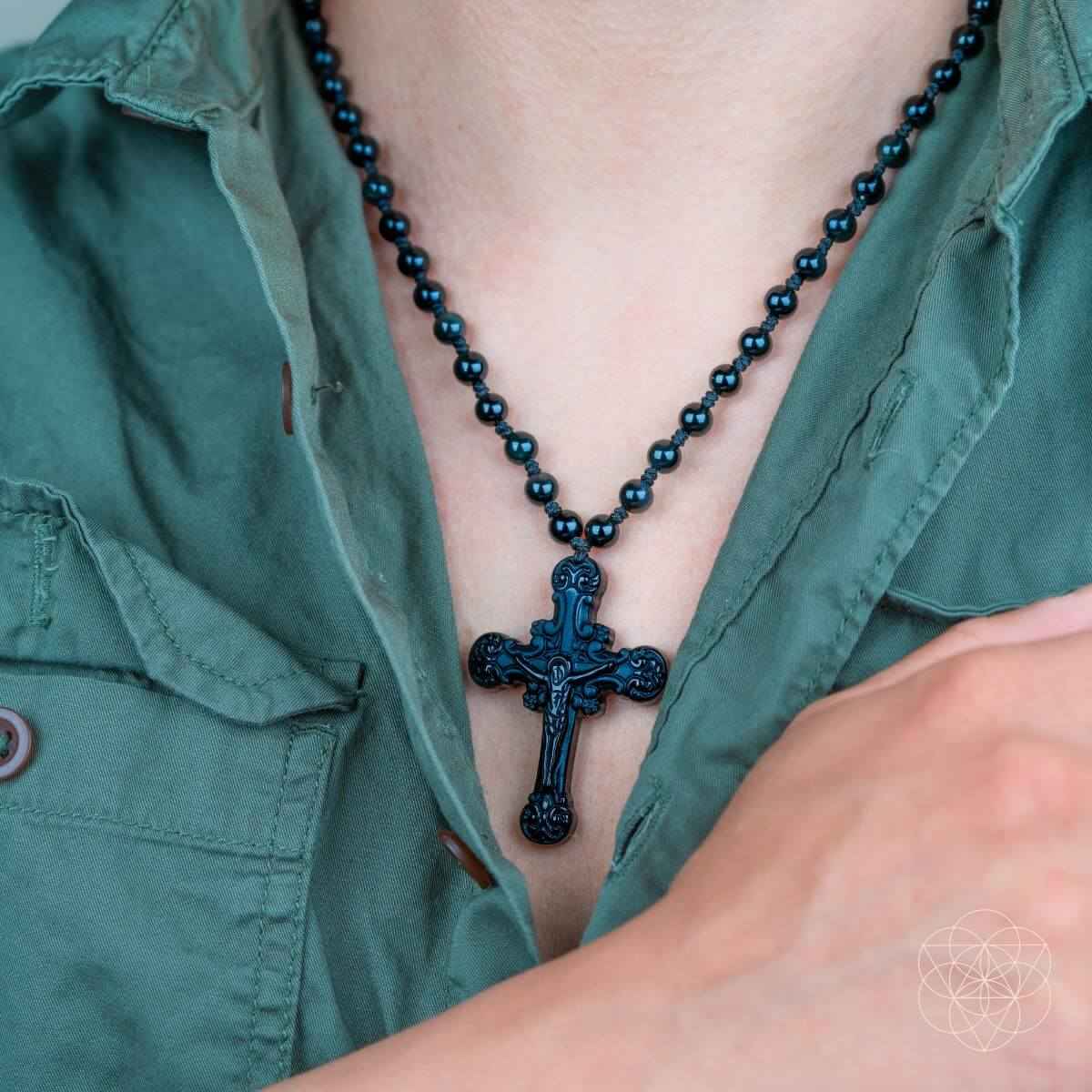 Black beaded cross pendant necklace with ornate crucifix at chest neckline