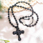 Black obsidian cross pendant bead necklace with ornate crucifix on dark beaded chain