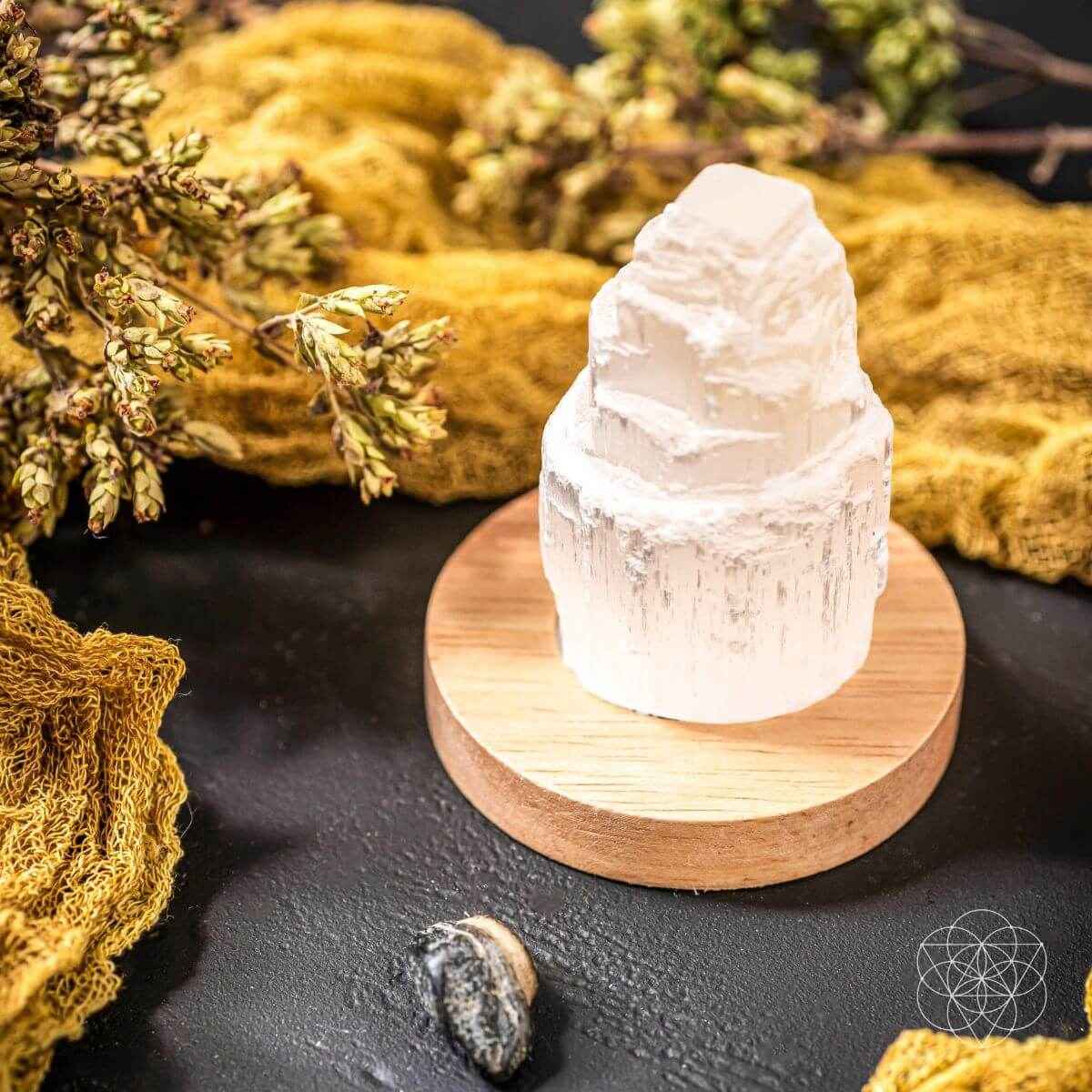 White selenite cleansing lamp crystal on round wooden base