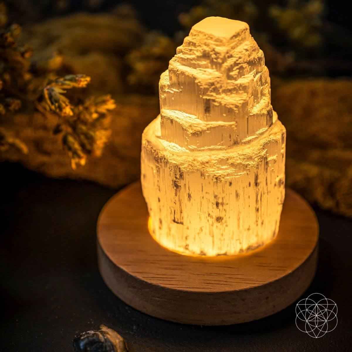 Selenite cleansing lamp glowing amber crystal on round wooden base