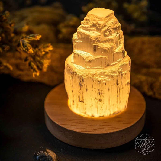 Selenite cleansing lamp glowing amber crystal on round wooden base