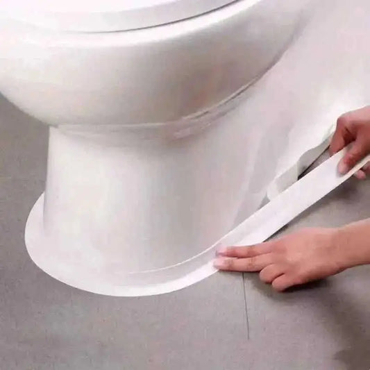Self-adhesive waterproof caulk strip smoothed along bathtub base seam, hands applying white tape