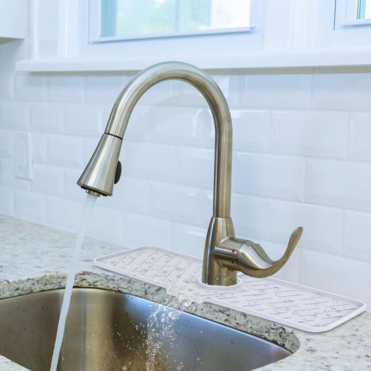 Light gray silicone sink mat with faucet cutout and embossed drainage channels