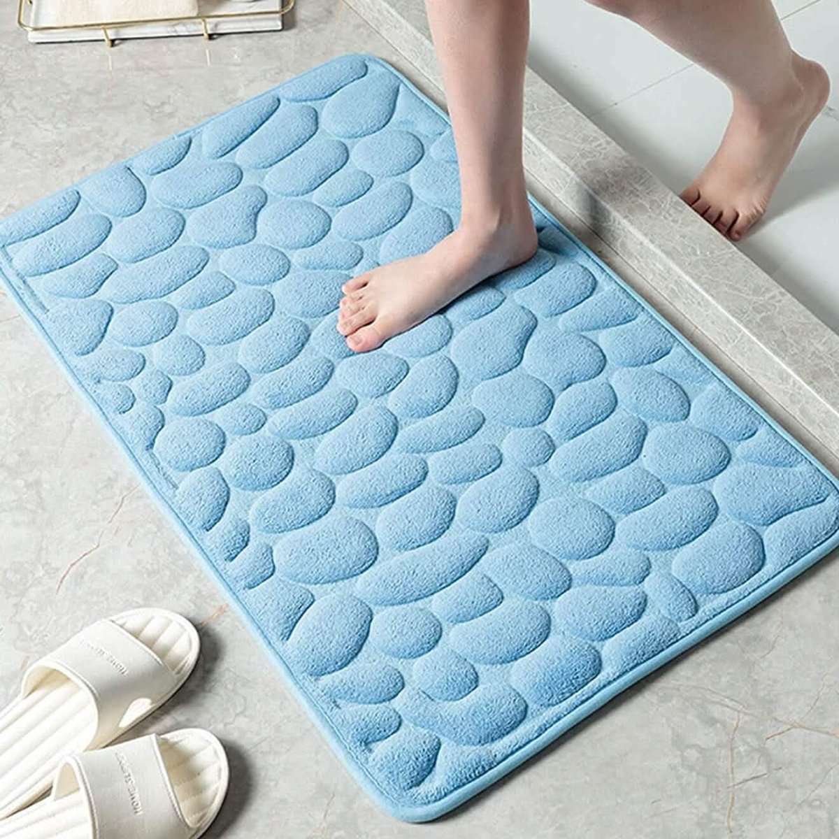 Light blue embossed bath mat with rounded pebble texture and non-slip backing