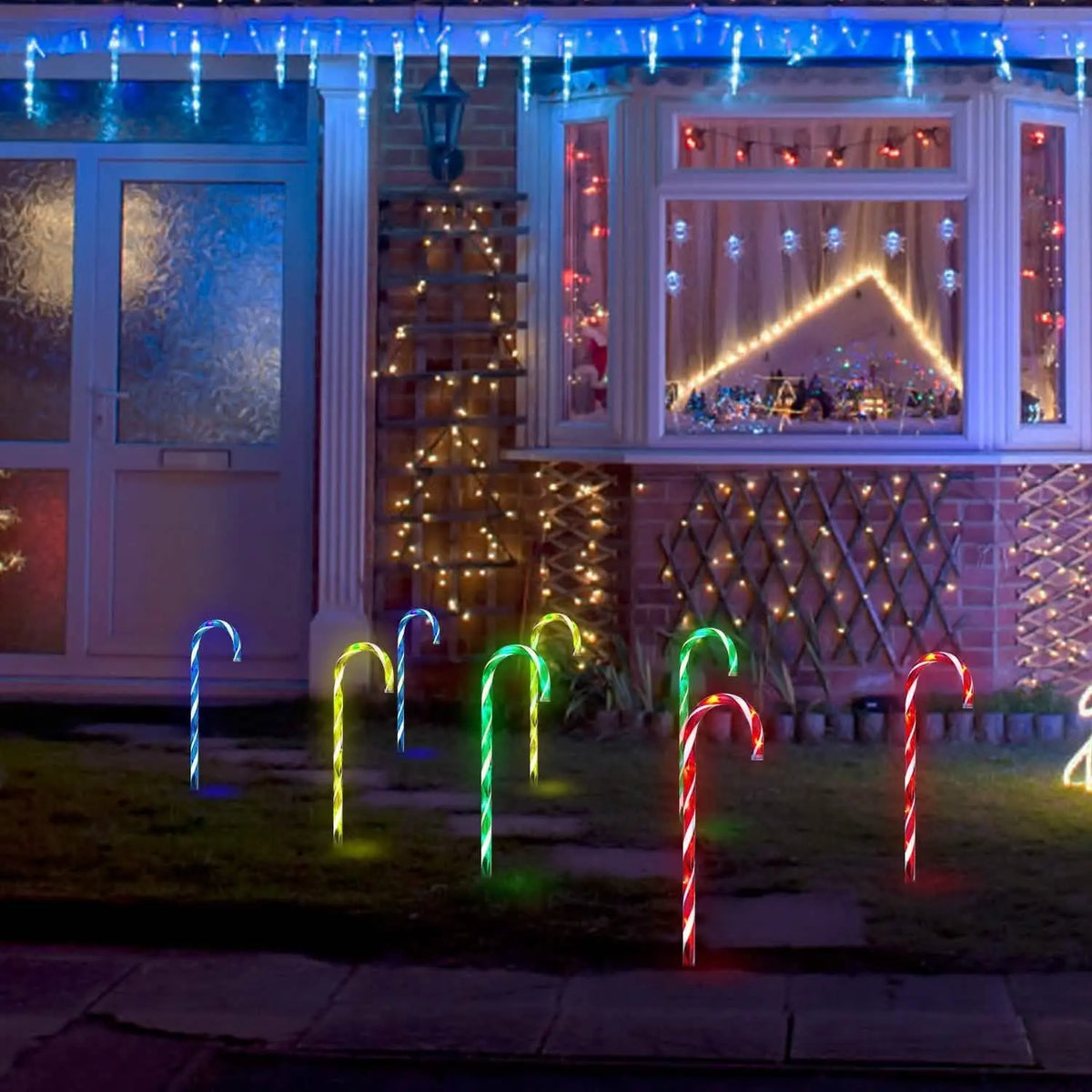 Solar candy cane stake lights with glowing multicolor curved candy shapes on yard