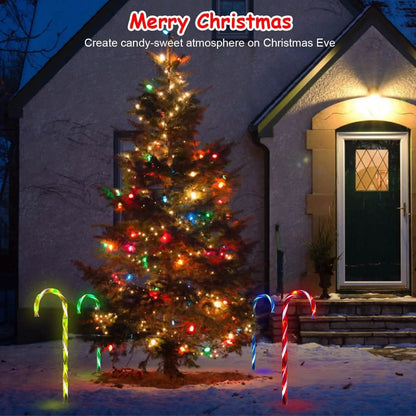 Solar candy cane stake lights with multicolor glow flanking a decorated outdoor Christmas tree