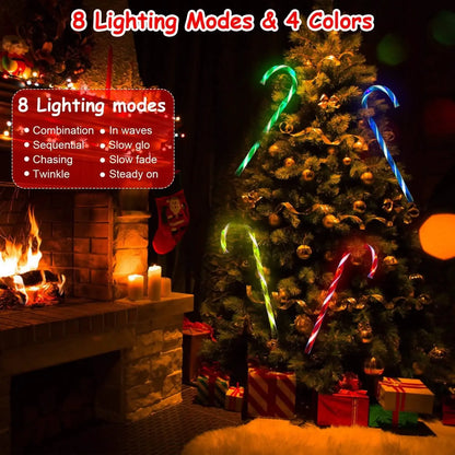 Multicolor solar candy cane stake lights glowing around a Christmas tree outdoors