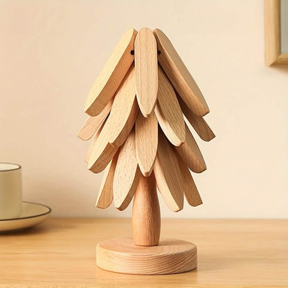 Light wood tree coaster with layered leaf cutouts and round base.