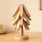 Light wood tree coaster with layered leaf cutouts and round base.