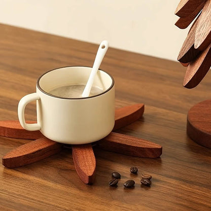 Dark wood tree-shaped coaster supporting a mug, with stacked leaf segments on base.