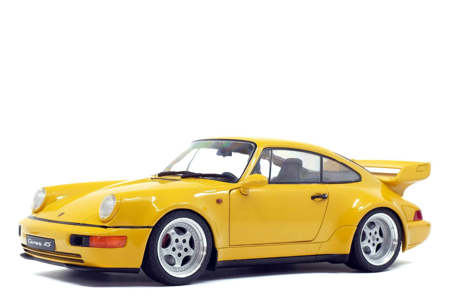 Yellow 1:18 Porsche 911 Carrera RS model car with rear wing, front 3/4 view