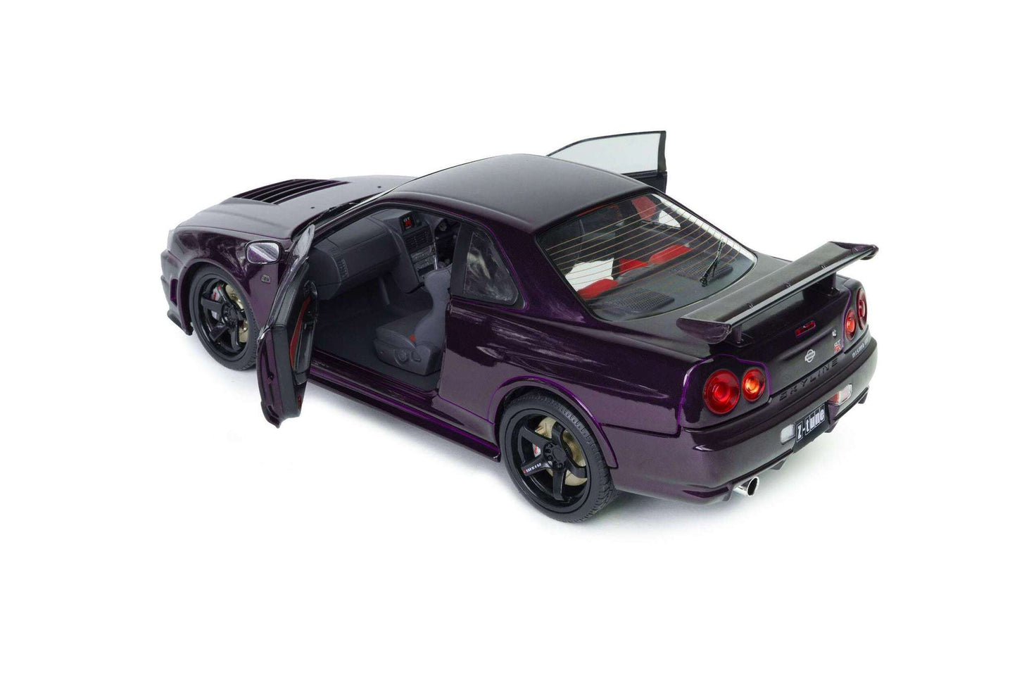 Rear three-quarter view of purple 1:18 Nissan Skyline GT-R die-cast model with tail lights
