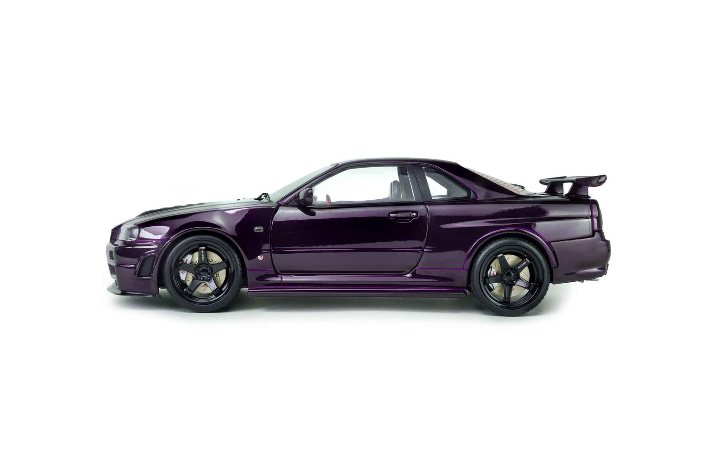 Purple 1:18 die-cast Nissan Skyline GT-R model in side profile, black wheels and spoiler