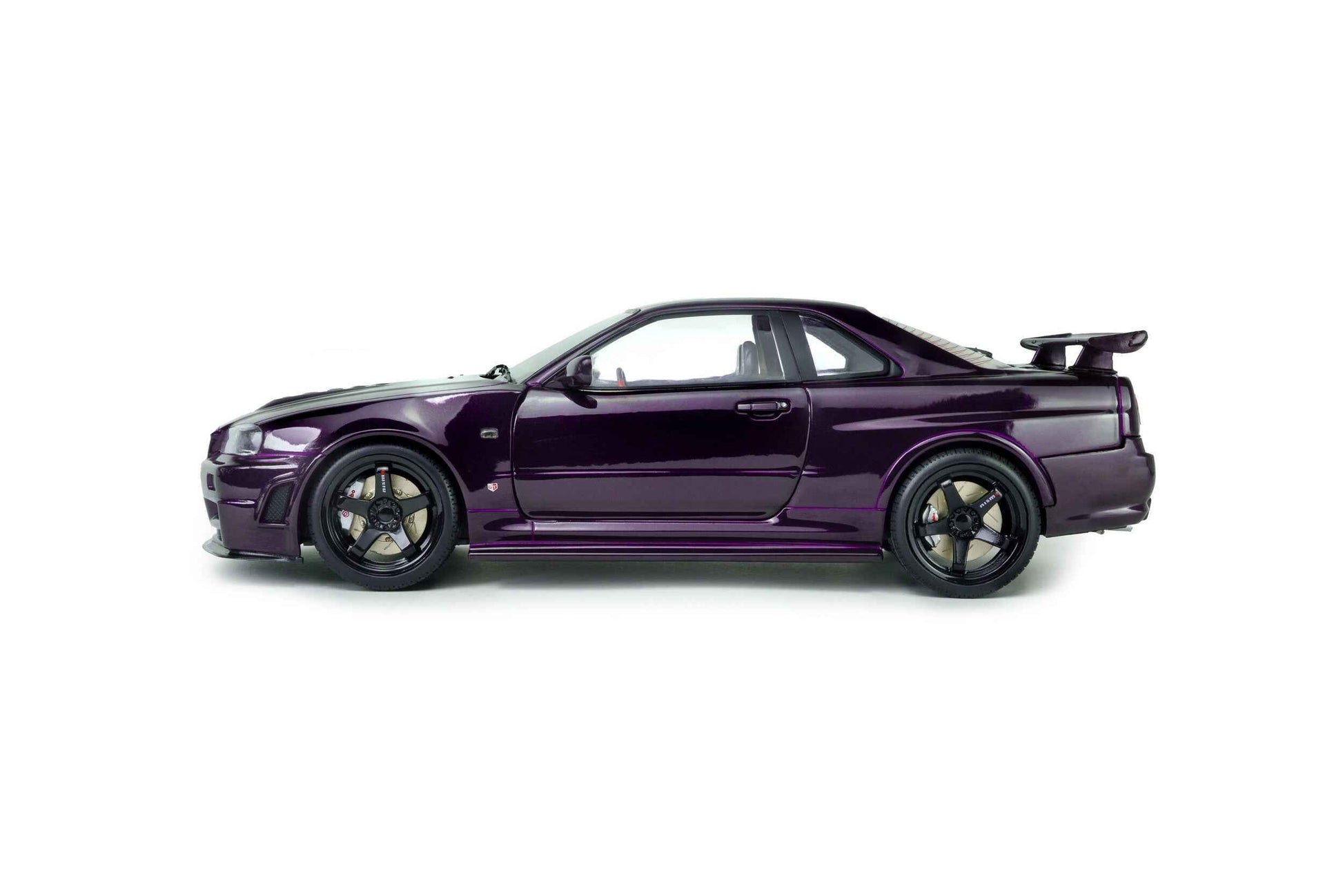 Purple 1:18 die-cast Nissan Skyline GT-R model in side profile, black wheels and spoiler