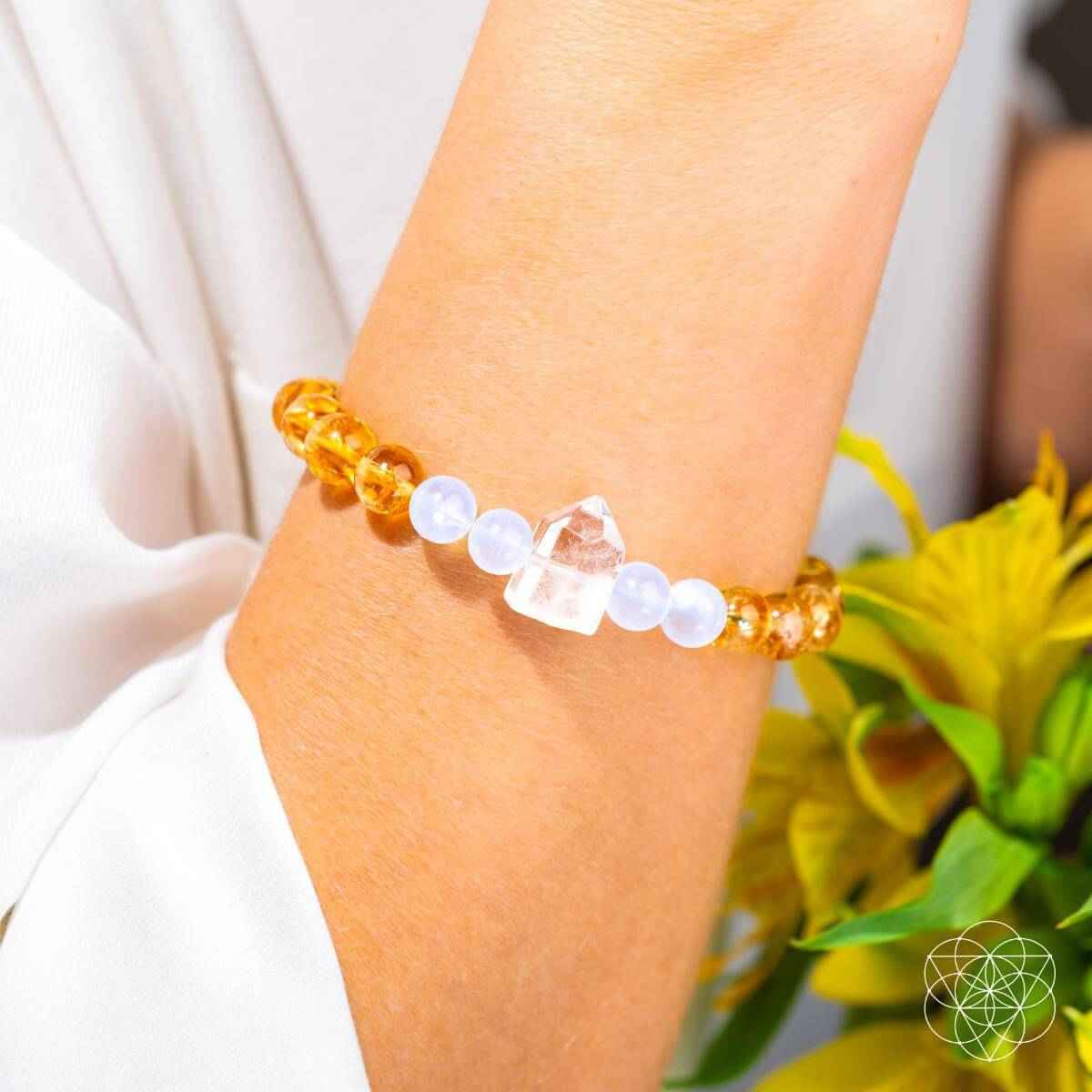 Gold and white beaded bracelet on wrist with crystal accents