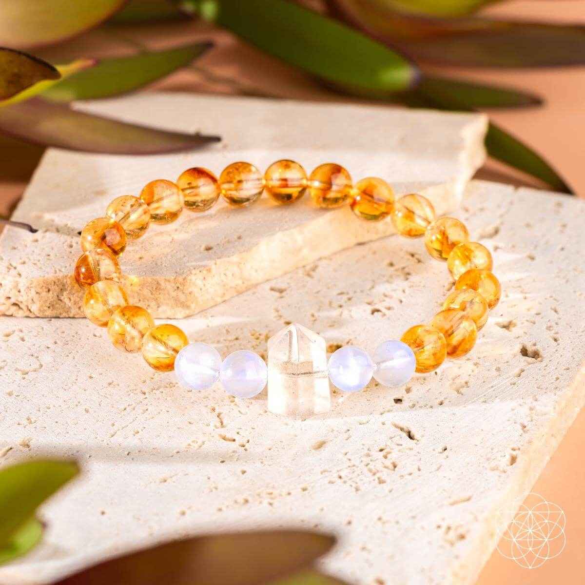 Gold beaded bracelet with white bead accents and central crystal bar