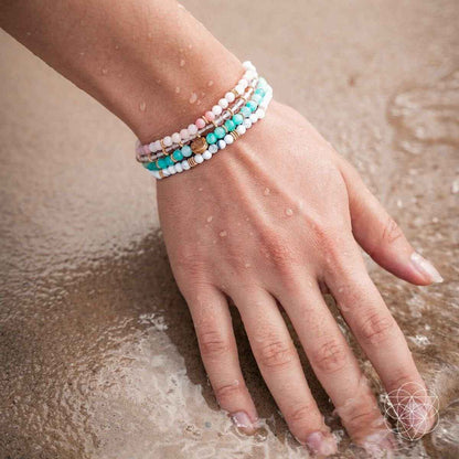 Turquoise and white beaded bracelet set on wrist with small gold spacer beads