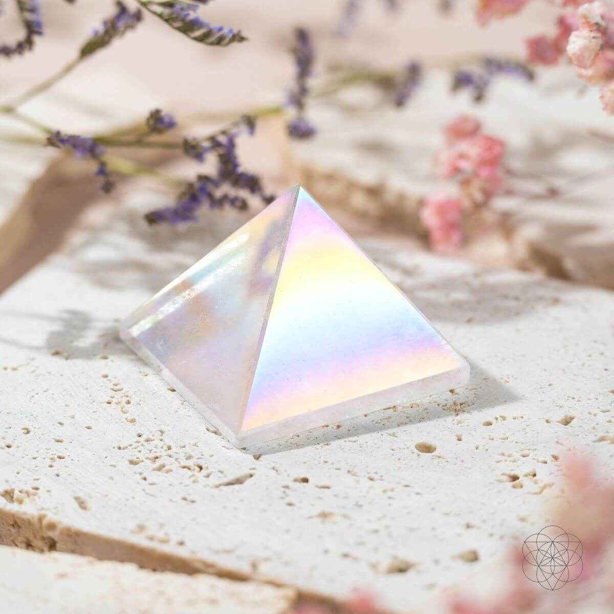 Iridescent angel aura crystal pyramid on white stone