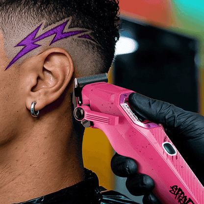 Pink electric trimmer trimming hair near ear, gloved hand holding tool.