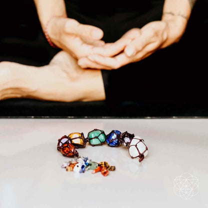 Chakra bead tassel with multicolor stones laid flat on a white surface