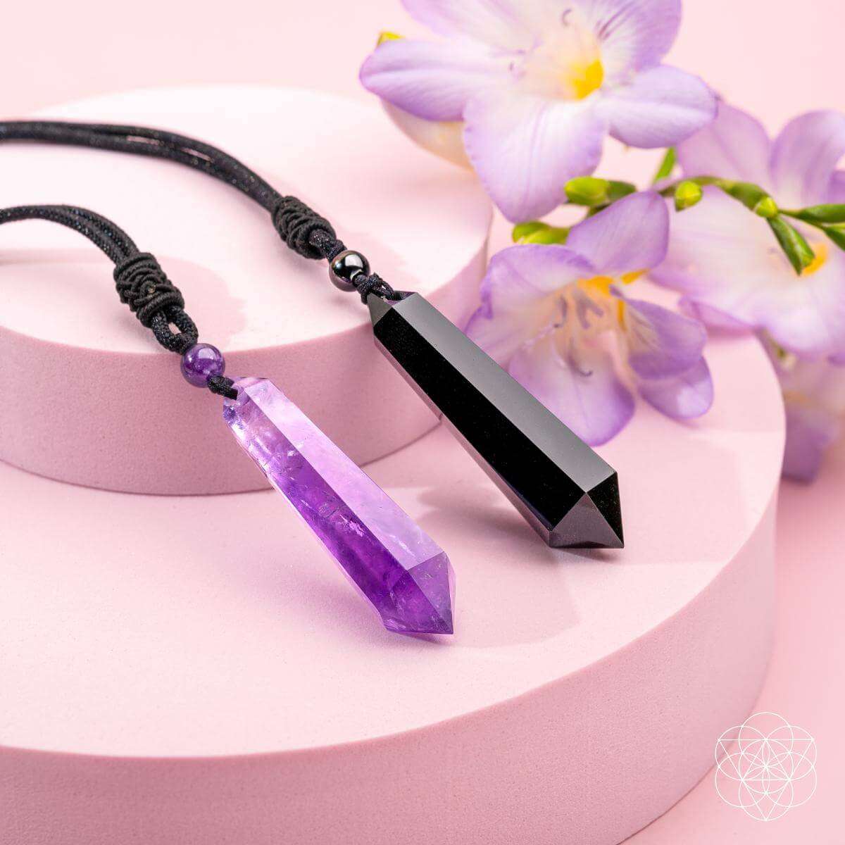 Two amethyst crystal pendant necklaces with black cords