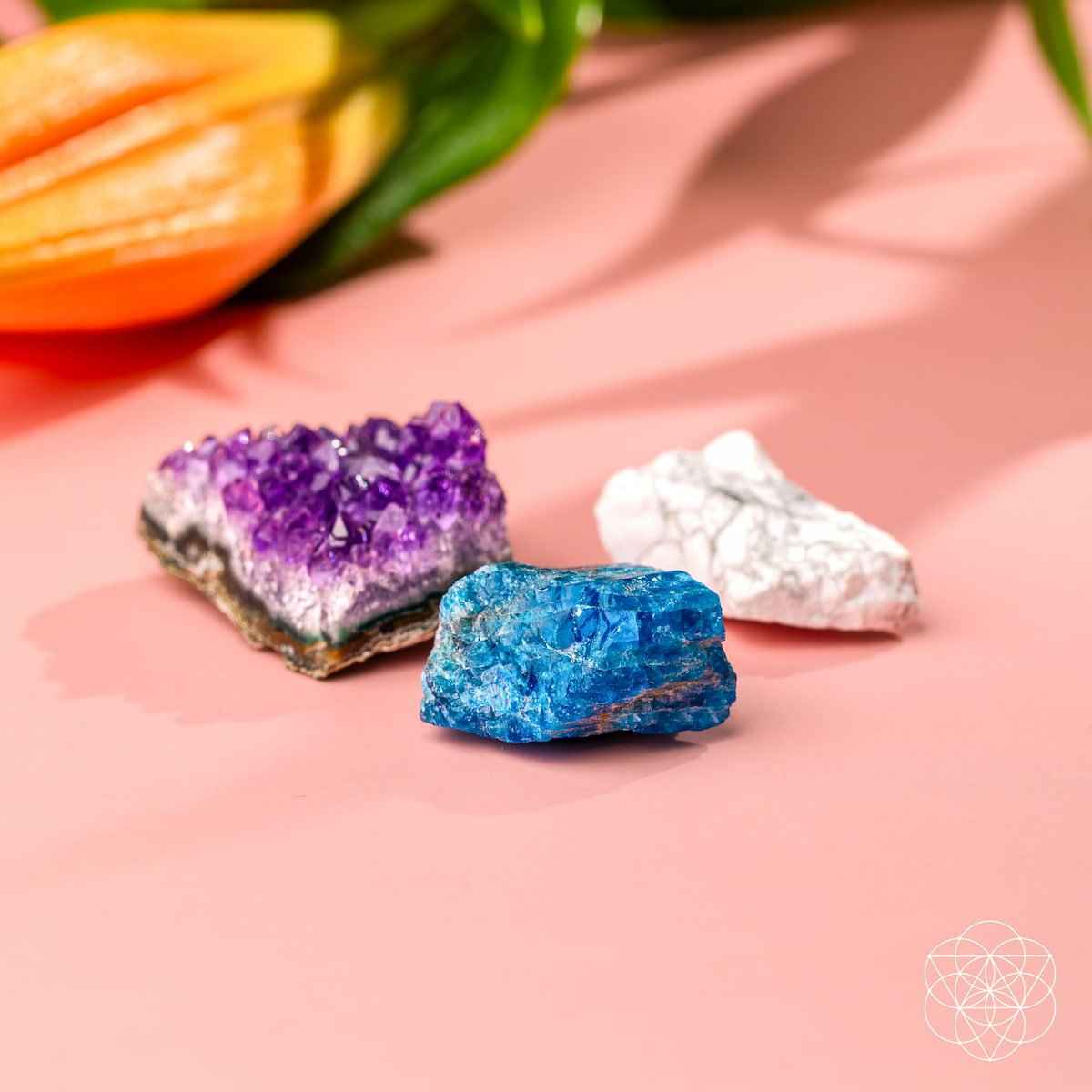Three crystal stones arranged: purple, blue, and white