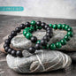 Double beaded bracelet set with black matte beads, green stone beads, and geometric charm