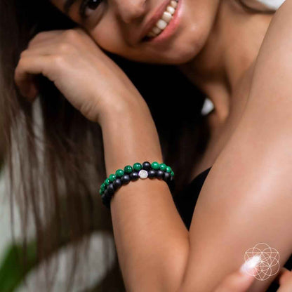 Double bracelet worn on wrist: black beads with green bead bracelet accents