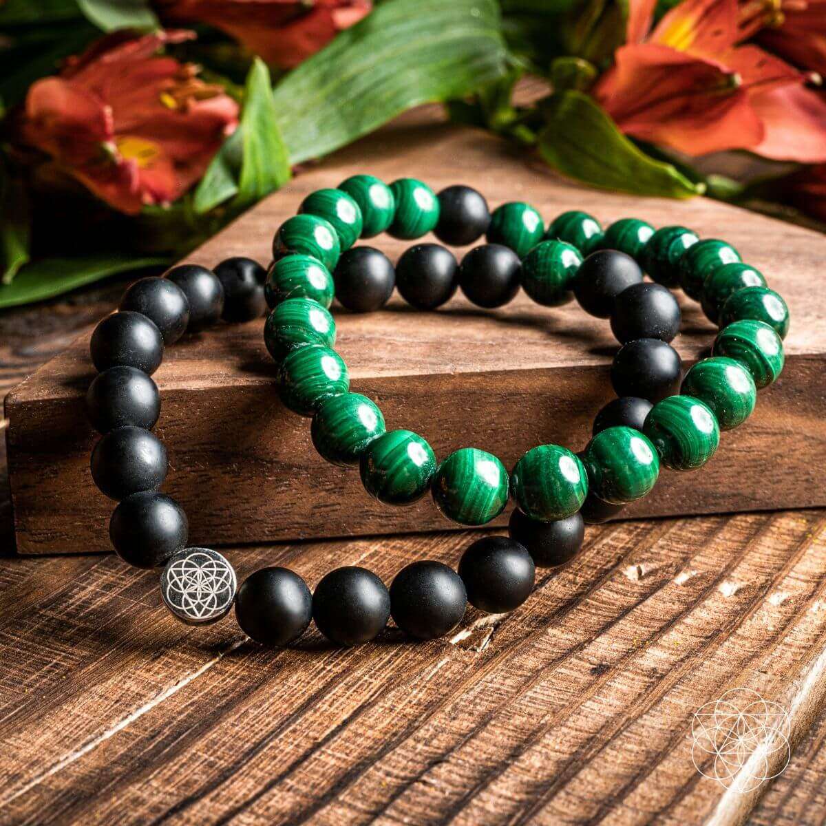 Layered double bracelet set with black beads and green stone beads on wooden surface