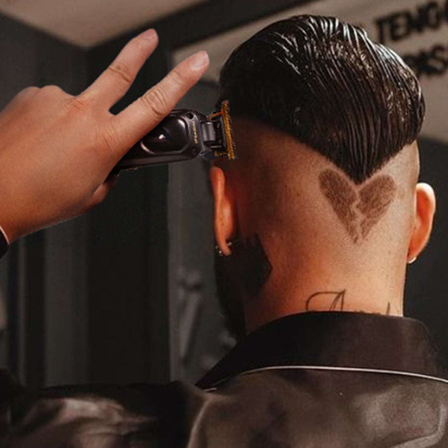 Black hair trimmer with gold blade trimming short hair on the scalp