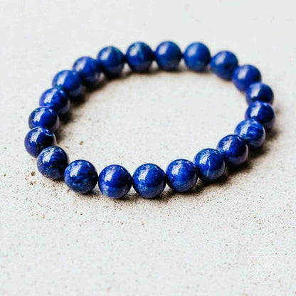 Blue beaded bracelet with round stones, front view on light background