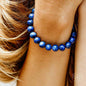 Blue beaded bracelet with round stones, worn on a wrist