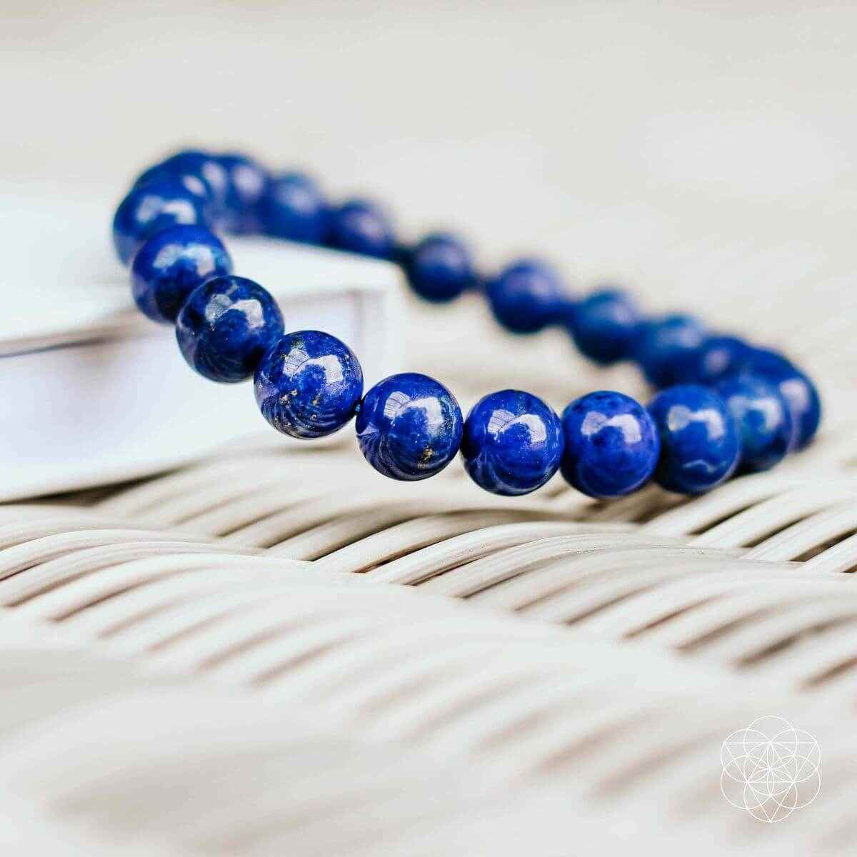 Blue beaded bracelet with round stones on folded fabric