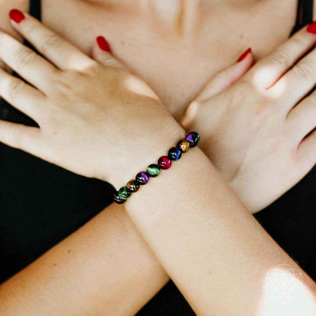 Multicolor bead bracelet on palm and wrist, round stones with elastic bead strand