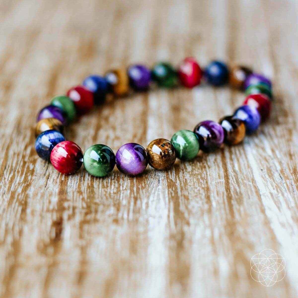 Beaded bracelet with multicolor round beads, laid on a light wooden surface