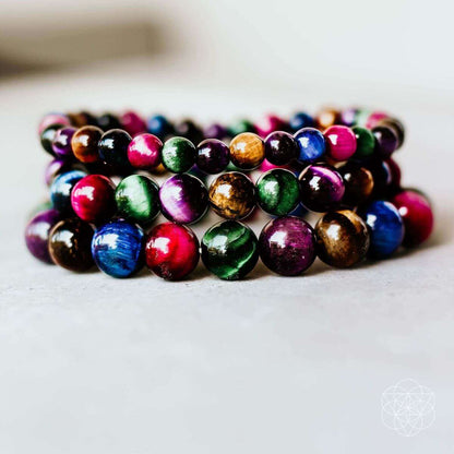 Stack of colorful beaded bracelets with round multicolor beads on a light background