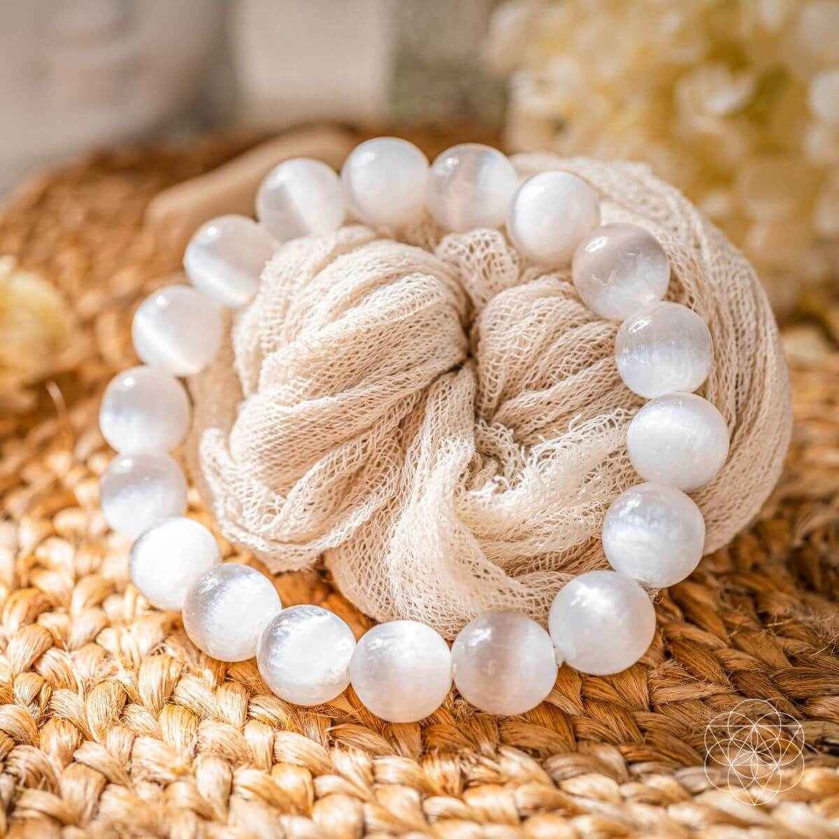 White beaded bracelet with smooth round stones on textured burlap pouch