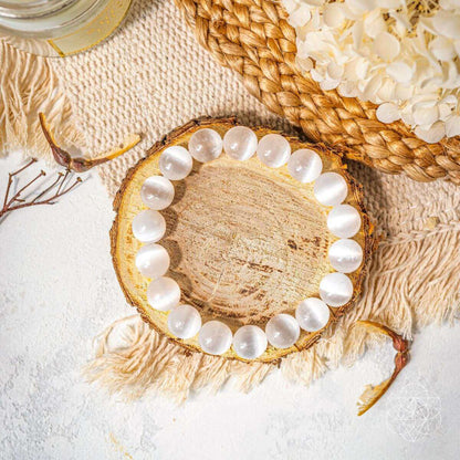 White beaded bracelet with round stones on wooden slice display