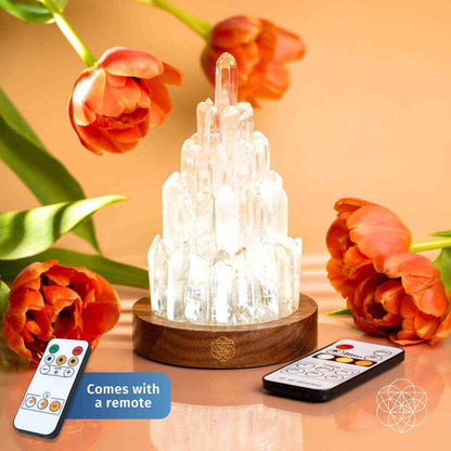 Clear quartz manifestation tower lamp with illuminated crystal tower on wooden base